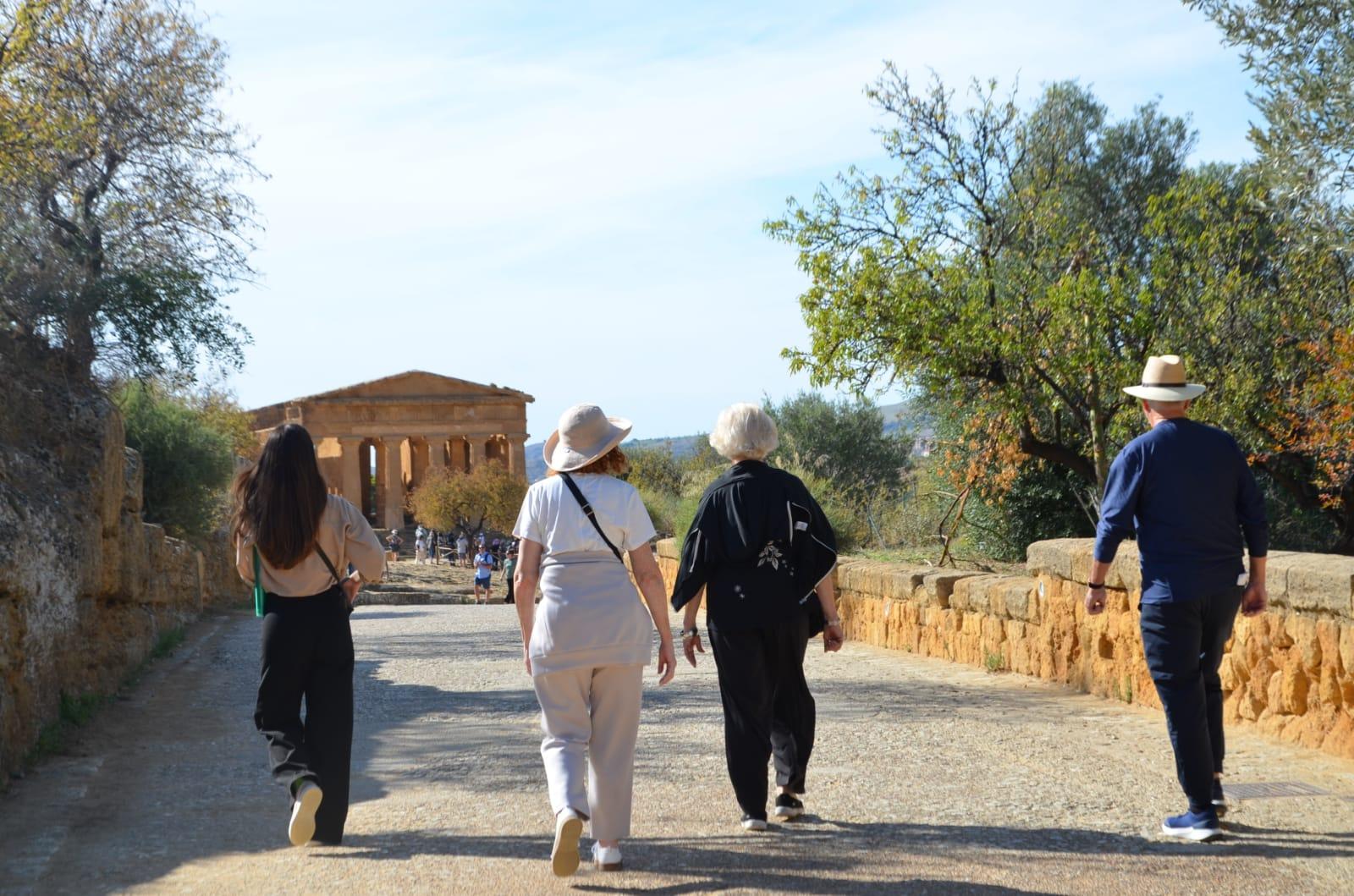 Guided tour group walking toward the Temple of Concordia in the Valley of the Temples, Agrigento, Sicily